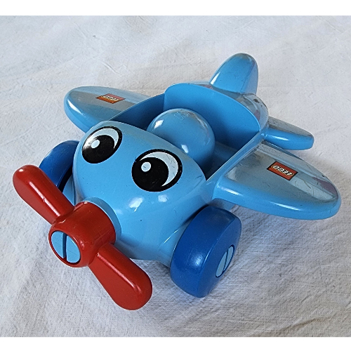 Primo Flugzeug, roter Propeller, blaue Räder, mit Augen, Flügel-Logo (bedruckt)