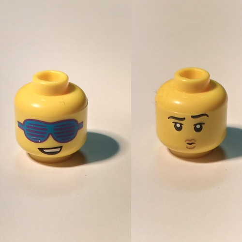 Minifig Head, Dual Sided, Lopsided Smile and Large Slotted Blue Sunglasses / Raised Eyebrow, and Small Pouting Mouth Gelb